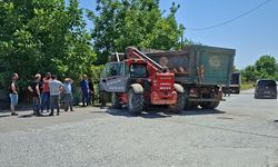 İş makinası ile çarpışan kamyon sürücüsü yaralandı